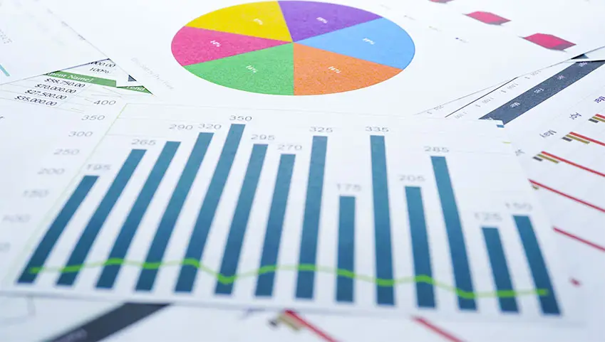 Charts and graphs printed out on paper and randomly displayed on surface